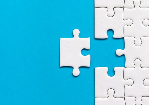 Businessman hands connecting puzzle pieces representing the merging of two companies or joint venture, partnership, Mergers and acquisition concept, puzzle with missing piece, acquisition
