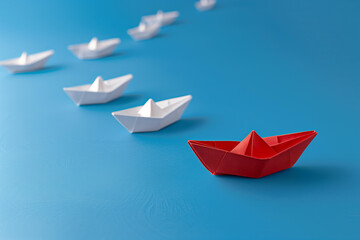 red paper boat leading other white boats on a blue background, symbolizing leader focus and strategic direction.