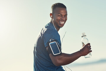 Black man, drink water and portrait in outdoors for running, thirst and hydrate on sports break. Person, blue sky and mineral liquid in bottle for nutrition, music and phone app for streaming song - obrazy, fototapety, plakaty