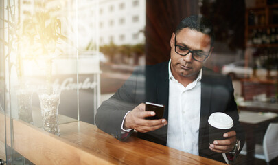 Fototapeta premium Coffee shop, business and man with smartphone, typing and texting contact for schedule and deadline. Person, employee and entrepreneur with morning tea and espresso with cellphone to message client