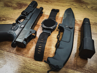 Set of men to carry, gun, magazine, knife and smart watch.