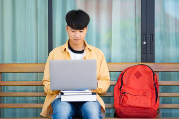 College Student Studying with Laptop on Outdoor Campus Bench