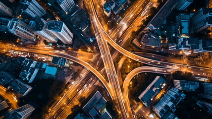 Fototapeta na wymiar Aerial view of city intersection and traffic at night with light trails. Urban infrastructure and transportation concept. Cityscape photography theme for design and print.