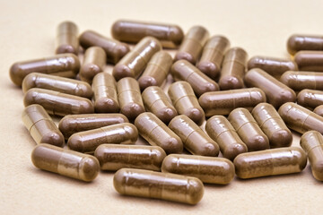brown capsules. a large number of small brown capsules lie on a white table, close-up, treatment concept
