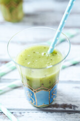 Green smoothie topped with chia seeds on bright wooden background. Close up.	