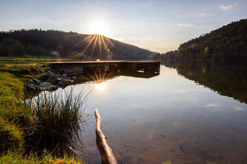 Lake in sunset. Beautiful landscape. Located in the middle of the forest and surrounded by nature, the reservoir offers a great atmosphere. Marbachstausee, Odenwald, Hesse, Germany - obrazy, fototapety, plakaty