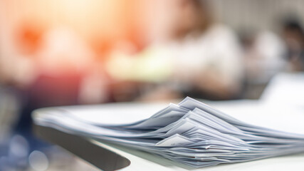 Exam answer sheet pile, blurry application document paperwork stack on office work table in...