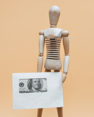 Wooden mannequin with an envelope with money. Concept for donation delivery, money transfer, lottery win, money back, value added tax refund and donation.