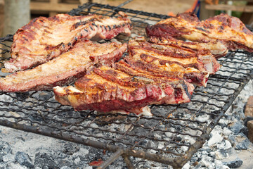 Close up view of roast meat cooking on a barbecue grill for a gathering with family or friends.