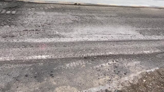  Camera pans over ripped up concrete for road repaving