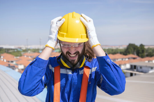 Stressed engineer grab his head suffer from acrophobia while working on the factory rooftop