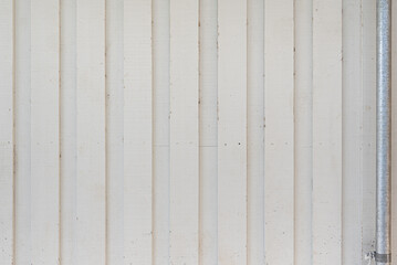 white wooden wall with vertical boards and steel pipe and the side