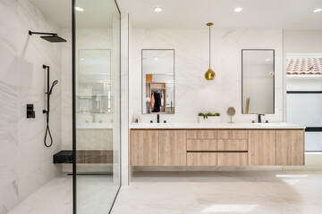 this bathroom has two large sinks and marble counters and glass shower doors