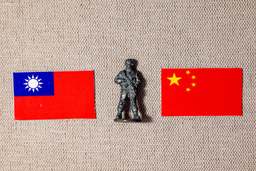 A soldier figurine on the background of the flags of China and Taiwan