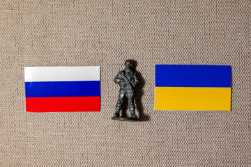 The figure of a soldier on the background of the flags of Russia and Ukraine
