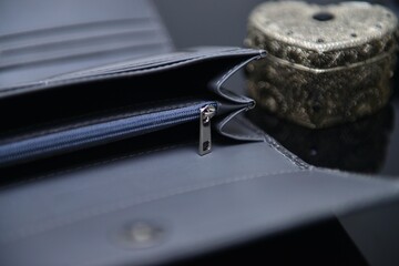 A grey color ladies' purse made with premium quality leather, placed on the table when it is...