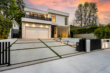 a garage and a driveway outside the house at dusk in los angeles, california