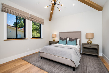 the large bedroom has two windows and a ceiling fan with lighting