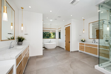 the bathroom has marble countertops and a large white tub