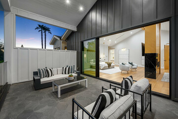 the patio features outdoor furniture and modern lighting, along with white walls and windows