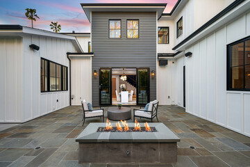 a stone fire pit is on the patio of a home