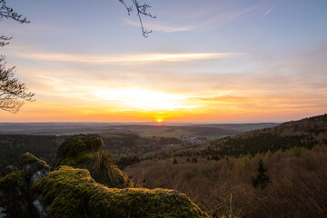 Panorama of a Romanesque landscape at sunset in the evening light. beautiful spring landscape in the mountains. Grass field and rolling hills. View from a rock to the horizon - obrazy, fototapety, plakaty