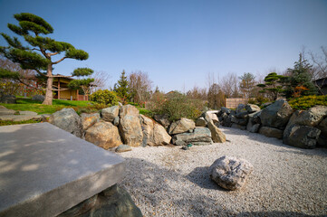 A kareike style dry pond in a Japanese garden in a public park. The stones are arranged to form a pond shape.	