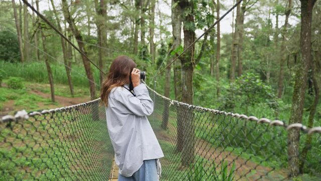 Female traveler photographer taking photo's of beautiful Cahuita natural rainforest on boardwalk