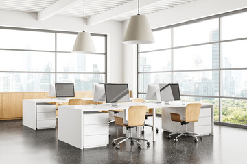 Stylish coworking interior with pc computers on desks in row, panoramic window
