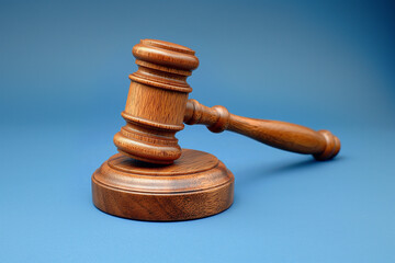 Wooden gavel on a light blue background.