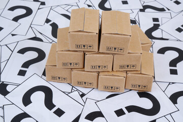 Goods and delivery FAQ concept. Many shipping carton boxes on question marks background.