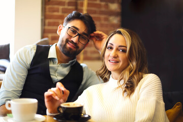 Couple at a restaurant eating dessert and drinking coffee