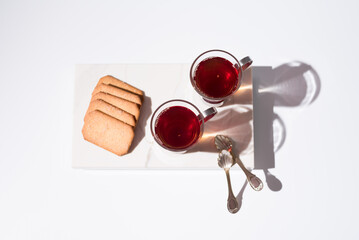 Dos tazas de té rojo con galletas sobre mármol. Vista superior