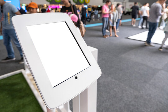 Mockup background texture of a digital monitor screen, kiosk machine or electronic device with touch function, blurry backdrop of a busy indoor event or exhibition.
