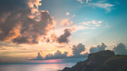 Tranquil ocean seaside rocky cliff clouds and sky during sunset