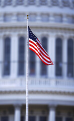American Flag Flying Proudly in Front of Blurred Building
