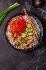 Bowl of rice noodles with vegan soy meat and vegetables.
