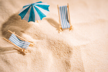 Striped sunbeds and umbrellas on the yellow clean sand of the beach.