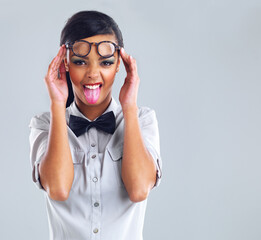 Funny, girl and emoji face with glasses for fashion in studio for designer, flirting and quirky on...