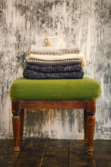 Pile of knitted warm grey and white blankets, scarves and woolen sweaters for winter or fall cold...