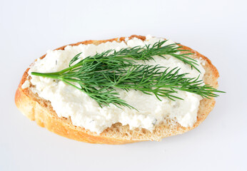 a bread with a white cream cheese and a green sprig of parsley on top 