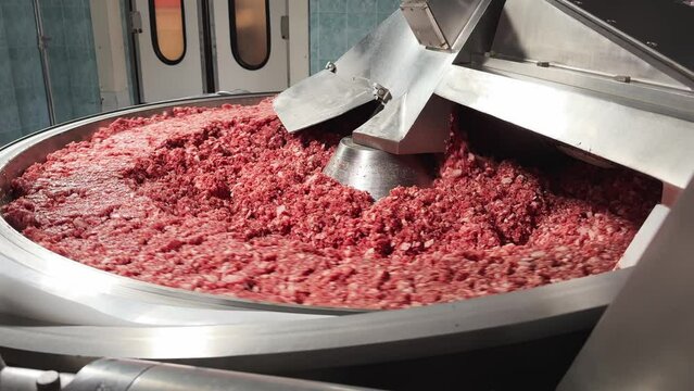 Processing of production minced meat in industrial meat grinder, close up. Modern technologies in Food industry