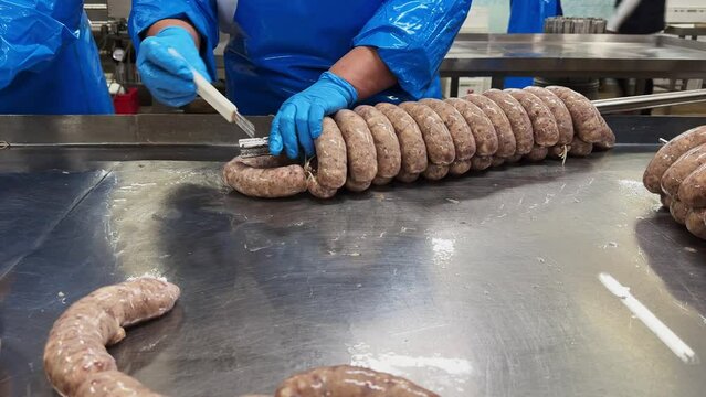 Close up of sausages production process at the meat factory. Food industry concept