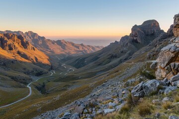 A weathered mountain pass bathed in the golden light of dawn, panoramic vista with winding trails