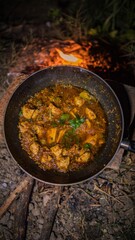 Overhead Shot of Rustic outdoor cooking over campfire, Chicken Karhai