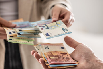 Businesswoman's hands exchanging euro banknotes, closeup shot - 783800004