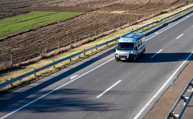 Gray modern delivery small shipment cargo courier van moving fast on motorway road to city urban...