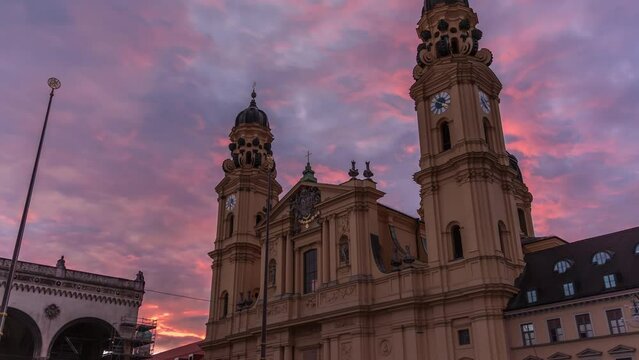 The Theatine Church of St. Cajetan (Theatinerkirche St. Kajetan) timelapse during sunset. A domed baroque Catholic church with striking yellow facade and ornate white stucco interior. Munich, Germany