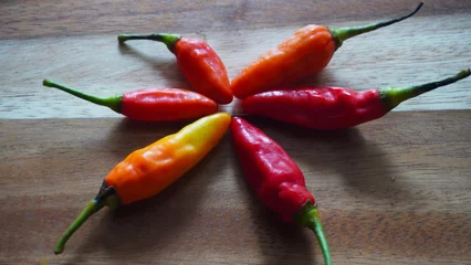 Fotobehang Isolated flat lay cayenne pepper or Capsicum annuum also commonly called Birds Eye on a wooden tray. Selective focus                             © Adhi Syailendra