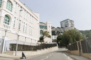 A street with a building on the right side of it. The building has a large window